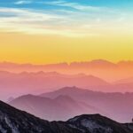 pexels-photo-1323550-1323550 Colorful sunrise over misty mountains in Altmünster, Austria with a lone hiker silhouette.