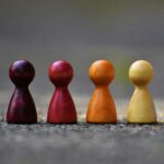 pexels-photo-209728-209728 Close-up of four colorful wooden pawn pieces arranged in a row.