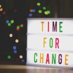 pexels-photo-2277784-2277784 Colorful illuminated sign displaying the motivational message 'Time for Change'.